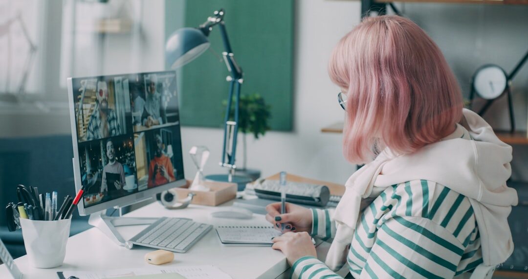 Journalist working at a desk with photos and a laptop reviewing entertainment news